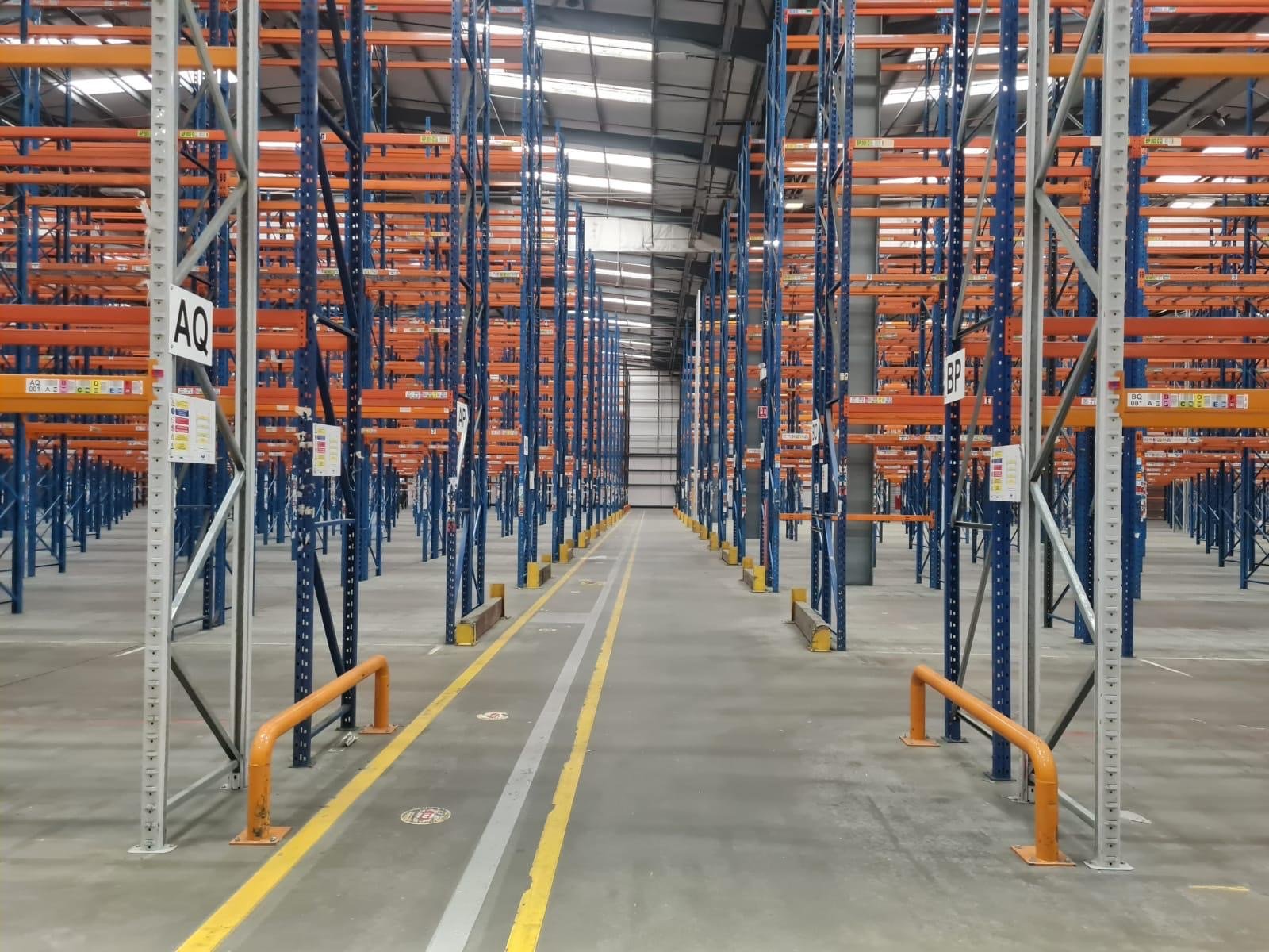 Orange forklift moving through a modern warehouse